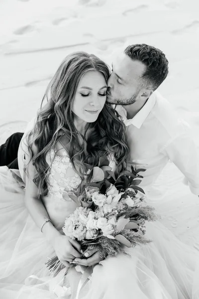 Güzel bir çiftin aşk hikayesi. Pembe bir gelinlik içinde Sahra Çölü 'nde bir buketi olan kumlar ve kumullar.