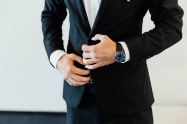 Otel eğitim kampındaki damadın portreleri. Siyah takım elbise, smokin ve beyaz gömlek giymiş bir iş adamı gibi giyinmiş.