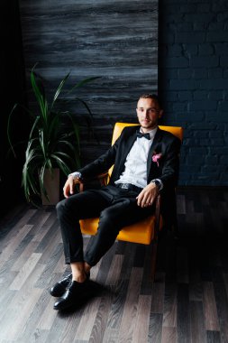 Otel eğitim kampındaki damadın portreleri. Siyah takım elbise, smokin ve beyaz gömlek giymiş bir iş adamı gibi giyinmiş.