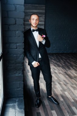 Otel eğitim kampındaki damadın portreleri. Siyah takım elbise, smokin ve beyaz gömlek giymiş bir iş adamı gibi giyinmiş.