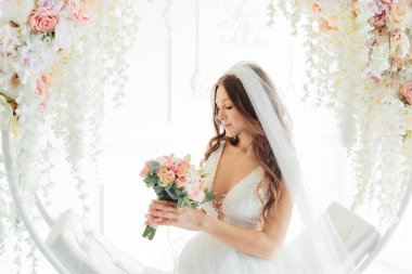 Damadın siyah takım elbiseli ilk buluşması ve beyaz gelinlikli gelinin beyaz ve siyah arka planda bir fotoğraf stüdyosunun içinde bir buket olması.