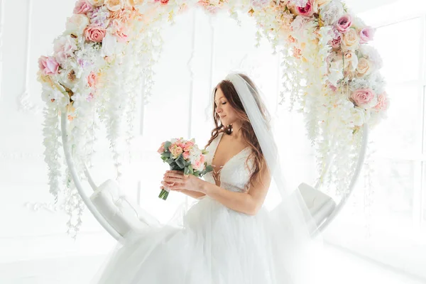 stock image The first meeting of the groom in a black suit and the bride in a white wedding dress with a bouquet in the interior of a photo studio on a white and black background