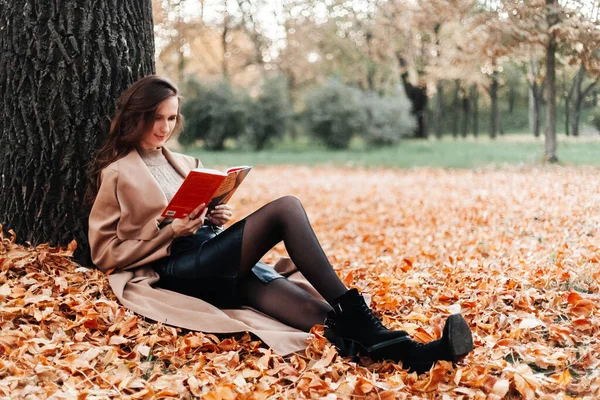 Paltolu güzel bir kız, siyah etek ve ceketli sonbahar yürüyüşleri şapkalı.