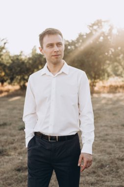 Güzel bir çift, kırmızı elbiseli bir kız ve beyaz gömlekli bir adam, parkta yürüyorlar.