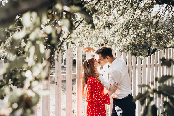 Güzel bir çift, kırmızı elbiseli bir kız ve beyaz gömlekli bir adam, parkta yürüyorlar.