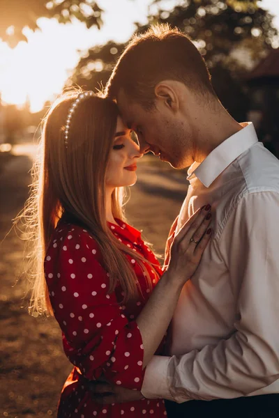 Güzel bir çift, kırmızı elbiseli bir kız ve beyaz gömlekli bir adam, parkta yürüyorlar.