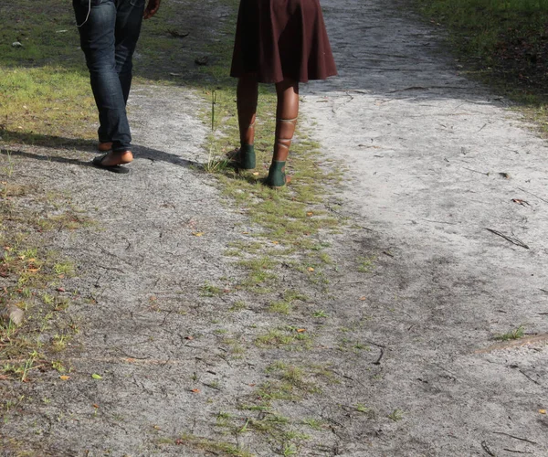 带着时尚鞋子的年轻女孩和她的伴侣在公园里散步 — 图库照片
