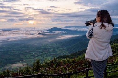 Kadın turist doğa manzara güneş sis Dağı Kış yüksek bakış açısı Phu Ruea Milli Parkı, Loei Eyaleti, Tayland, sunrise sırasında fotoğraf çekmek bir Dslr fotoğraf makinesi kullanıyorsanız