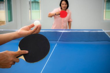 Yetişkin Asyalı kadın masa tenisi ya da masa tenisi oynamak için bekliyor. Evde spor müsabakaları, spor müsabakaları, dinlenme ya da egzersiz ile boş zaman Tayland 'da ailesiyle evde kal
