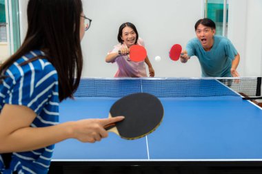 Masa tenisi ya da evde pinpon oynayarak ya da spor müsabakalarında yarışarak eğlenmek için. Baba, anne ve kız Asyalı aile, Tayland 'da dinlenme egzersizinin tadını çıkarın.