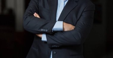 Adam akıllı bir takım elbise bir pasajda katlanmış silah ile ayakta
