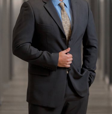 Elleri ceplerinde bir pasajda akıllı takım elbiseli kırpılmış kafa adam ayakta