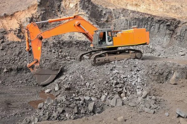 挖掘机挖掘富矿岩并将其装载到岩石转储卡车上进行加工 — 图库照片