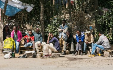 Addis Ababa, Etiyopya, 30 Ocak 2014, küçük bir grup Afrikalı erkekler bir otobüsün yan tarafına gelirlerse sakin bir banliyö sokakta bekleyen