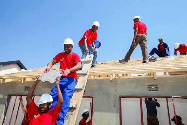 Soweto, South Africa, September 10, 2011,  Diverse Community members building a low cost house as a team in Soweto