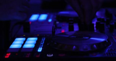 Dj oynayan bir karanlık gece kulübü ortamında dijital bir denetleyicisinde ele yakın çekim