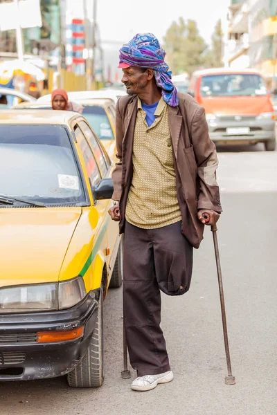 Addis Ababa, Etiyopya, 27 Ocak 2014, eski Arapça adam sessiz şehir sokak yanında sarı bir taksi koltuk değneği kullanarak