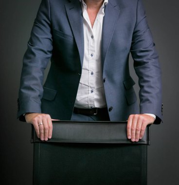 Yakın çekim Kafkas ellerini ve kollarını bir sandalyeye eğilerek işadamı kırpılmış