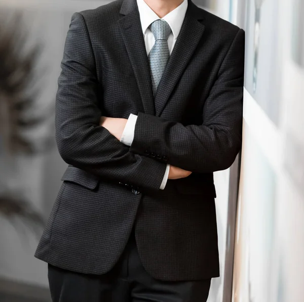 Akıllı takım elbiseli kafa adam ayakta bir ofiste katlanmış silah ile kırpılmış