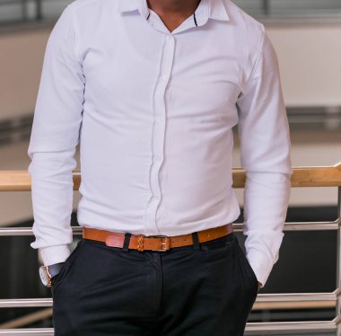 Akıllı elbise gömlek kırpılmış kafa adam ayakta elleri ceplerinde bir ofiste olan