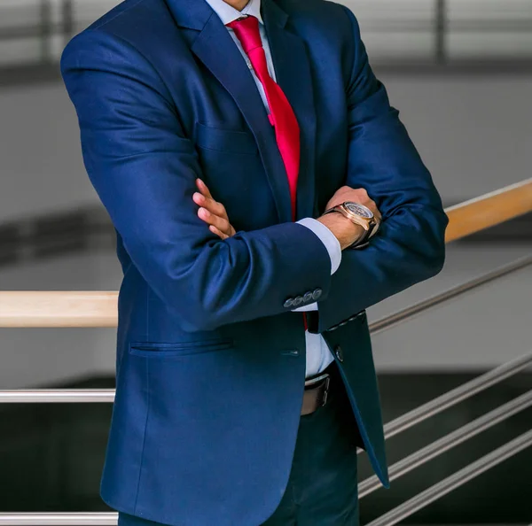 Akıllı takım elbiseli kafa adam ayakta bir ofiste katlanmış silah ile kırpılmış