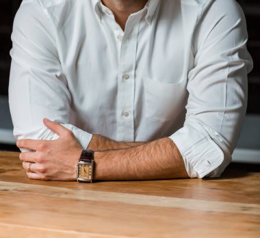 Kırpılan kafa Genç beyaz adam bir masa üzerine eğilerek akıllı elbise gömlek