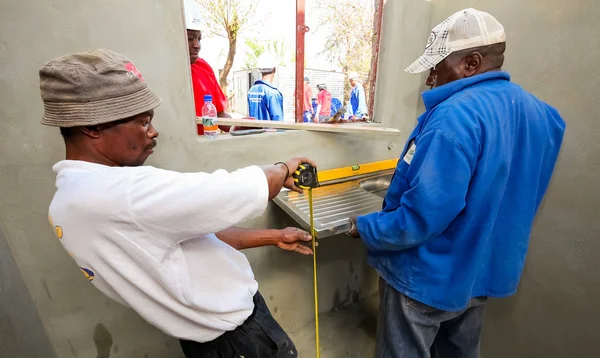 Soweto, Güney Afrika, 10 Eylül 2011, çeşitli topluluk üyeleri Soweto bir takım olarak düşük maliyetli bir ev binada Pwc'ın personel katılmak