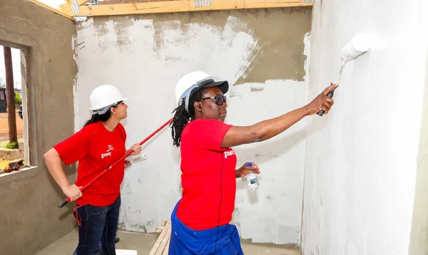 Soweto, Güney Afrika, 10 Eylül 2011, çeşitli topluluk üyeleri Soweto bir takım olarak düşük maliyetli bir ev binada Pwc'ın personel katılmak