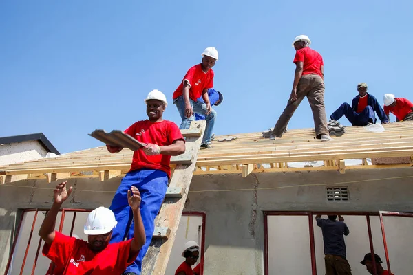 Soweto, South Africa, September 10, 2011,  Diverse Community members building a low cost house as a team in Soweto