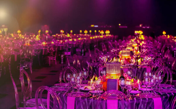 Розовый и фиолетовый рождественский декор со свечами и лампами для большой вечеринки или гала-ужина
