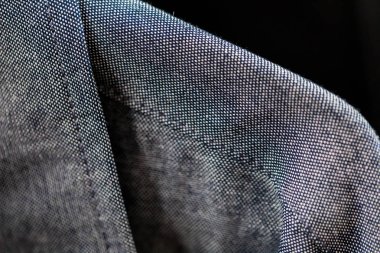 Yumuşak odak makro yakın karanlık bir arka plan karşı dikişli mavi kot