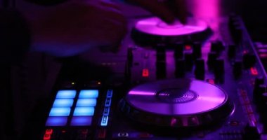Dj oynayan bir karanlık gece kulübü ortamında dijital bir denetleyicisinde ele yakın çekim