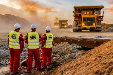 Rustenburg, Güney Afrika, 15 Ekim 2012, büyük platin cevheri madenciliği Emanet müfettişleri ön planda ile işlenmek taşıyan kamyonlar dökümü