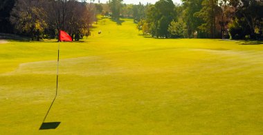 Öğleden sonra ışık gölge ile bayrak ile Golf Sahası yeşil delik