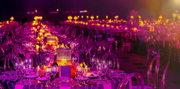 Розовый и фиолетовый рождественский декор со свечами и лампами для большой вечеринки или гала-ужина
