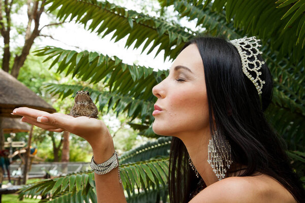 Johannesburg, South Africa - February 08 2013: Princess kissing a frog in a garden