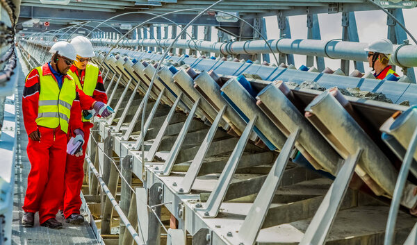 Рустенбург, Южная Африка, 15 октября 2012 года, Транспортный пояс платиновой палладиевой руды для переработки с инспекторами горной безопасности, проверяющими на повреждение
