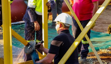 Esnaf bir inşaat alanında bir açı öğütücü ile çalışma