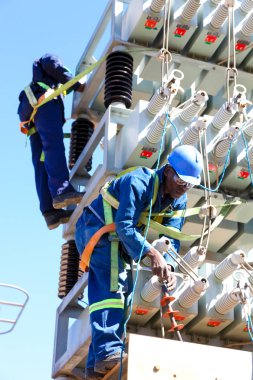 Yüksek gerilim enerji hatları üzerinde çalışan elektrikçiler