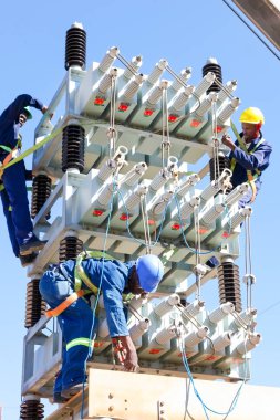 Yüksek gerilim enerji hatları üzerinde çalışan elektrikçiler