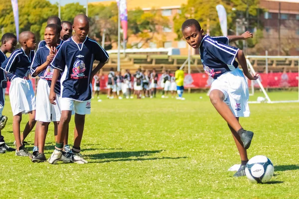 Diversos niños jugando fútbol en la escuela — Foto de Stock