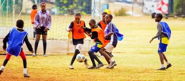 Різноманітні дітей, що грають футбол-футбол в школі — стокове фото