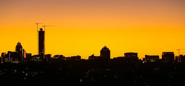 Силуэт заката Skyline с видом на строительные краны и — стоковое фото