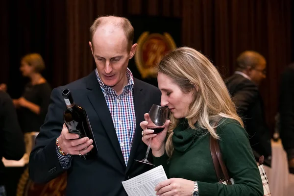 Sofistikerade människor provtagning vin vid en vinprovning händelse — Stockfoto