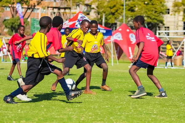 Diversos niños jugando fútbol en la escuela — Foto de Stock