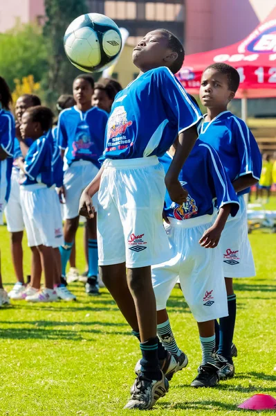 Diversos niños jugando fútbol en la escuela — Foto de Stock