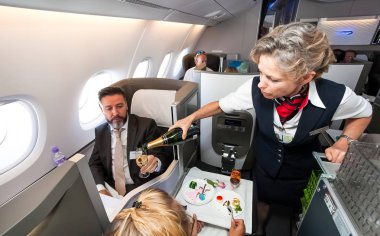 Kadın kabin ekibi business class champaign bir bardak dökme