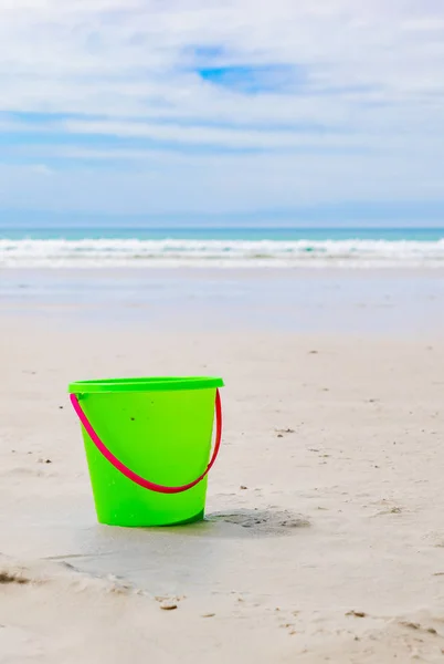 Cubo de plástico para niños para hacer castillos de arena en una playa de arena — Foto de Stock