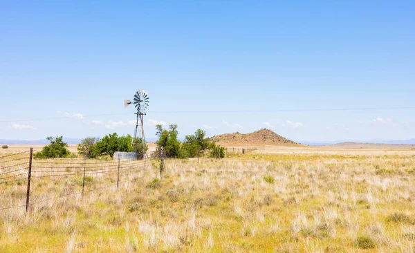 Molino de viento en una granja en la zona de pastizales rurales de Sudáfrica — Foto de Stock