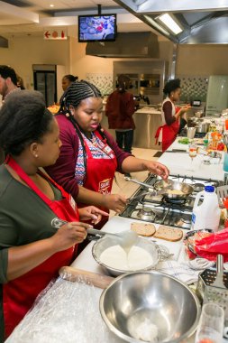 Johannesburg, Güney Afrika - 05 Ekim 2017: Genç Afrikalı kadınlar yemek pişirme ve pişirme kursunda öğreniyor
